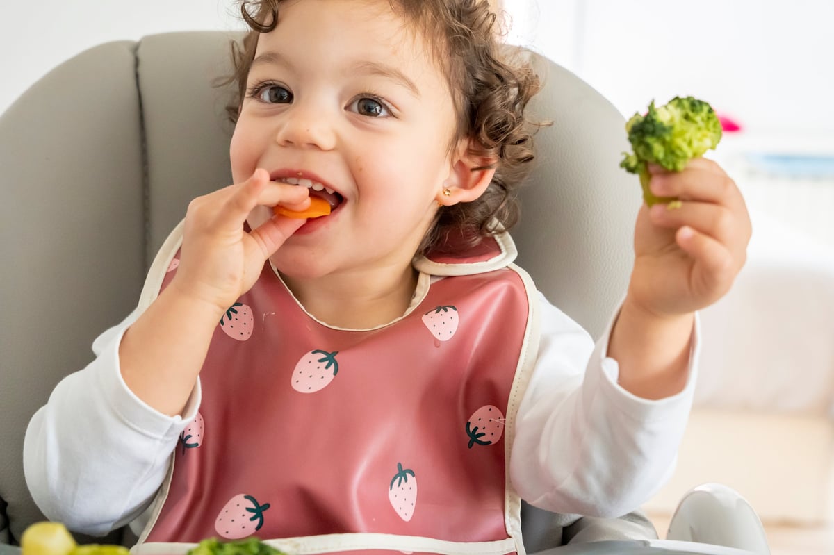 Happy child eating vegetables for healthy gut