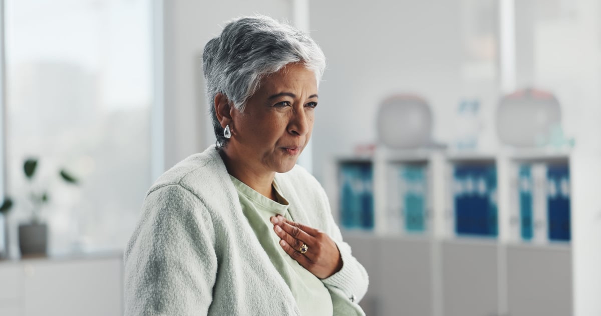 Woman experiencing heartburn and chest discomfort from acid reflux